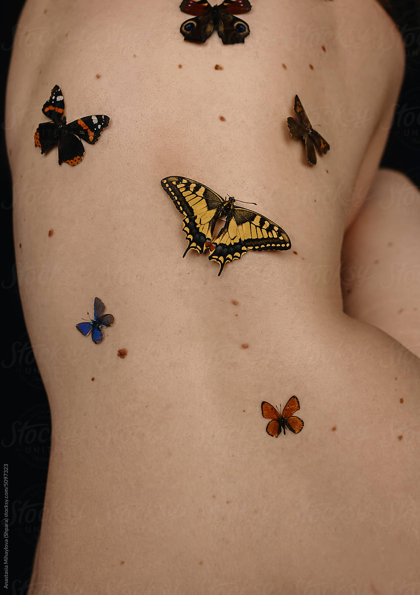 Close up photo of the woman\'s skin texture with moles and butterfly