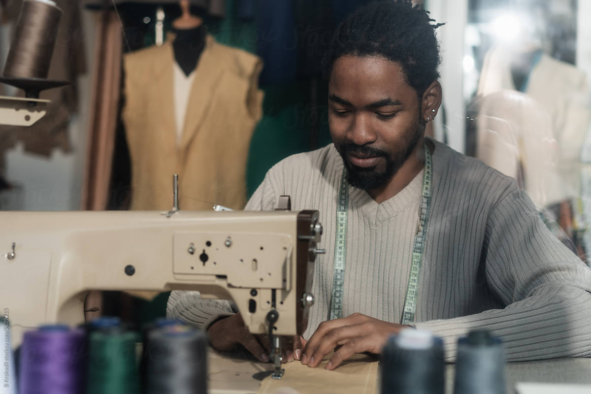 Man Working On The Sewing Machine In His Tailor Workshop