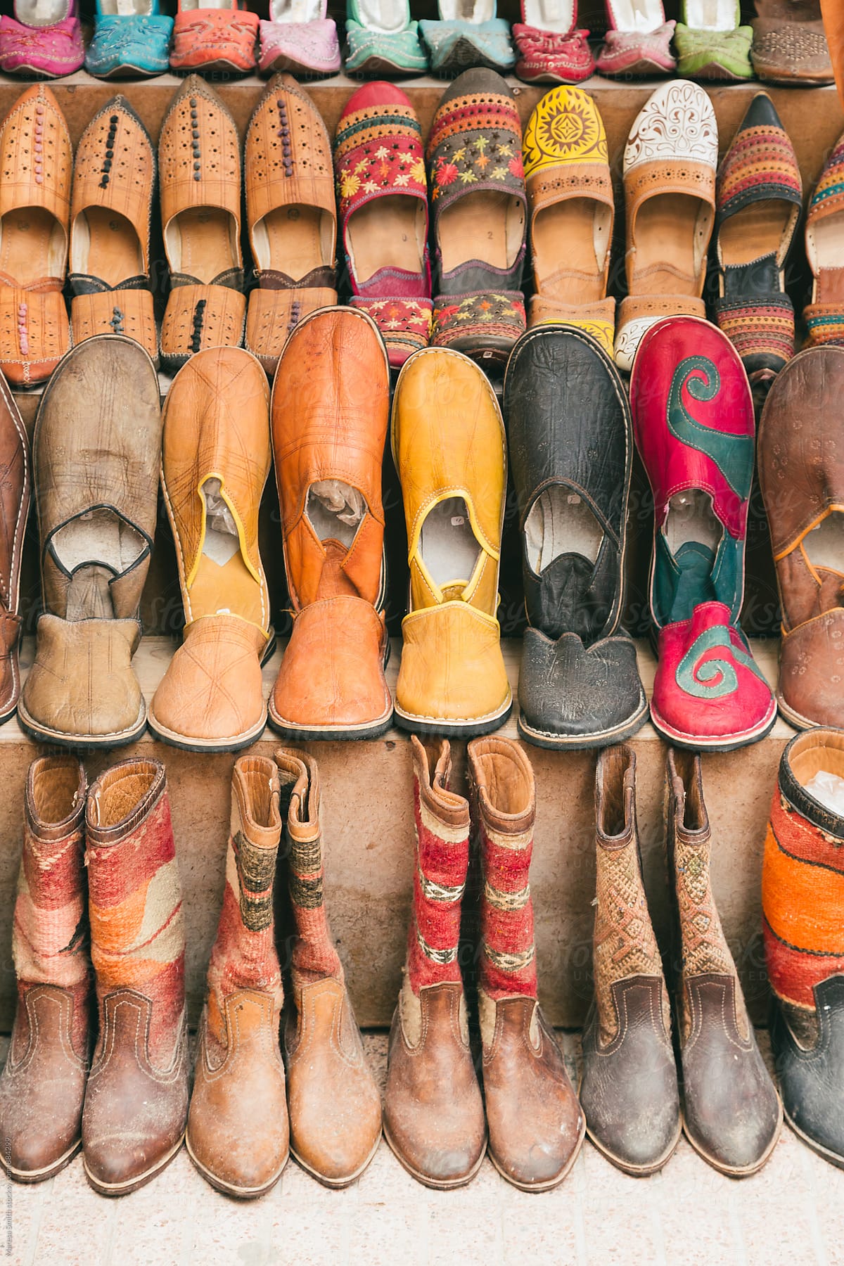 Moroccan slippers and boots stacked up at a market stall in Essaouira