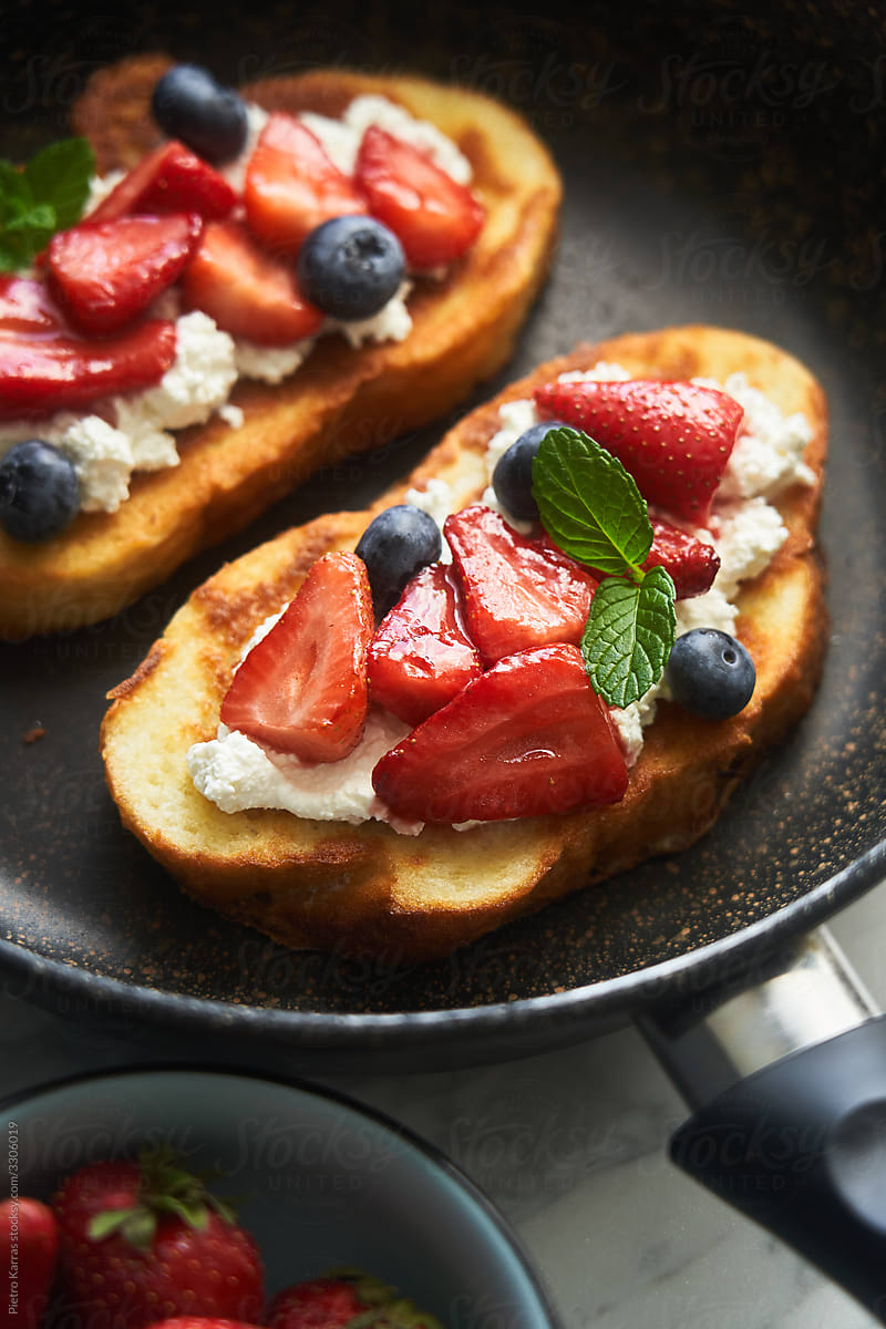 Freshly cooked toasts with berries in pan