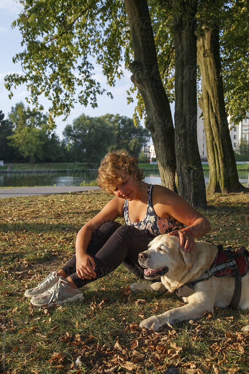 Calm woman with dog resting in park