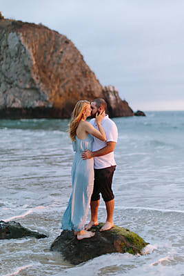 Young Couple Embracing And Spinning In Ocean Waves by Stocksy