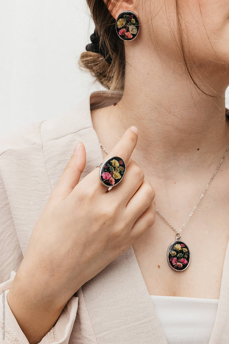 woman wearing floral epoxy necklace, earrings and ring