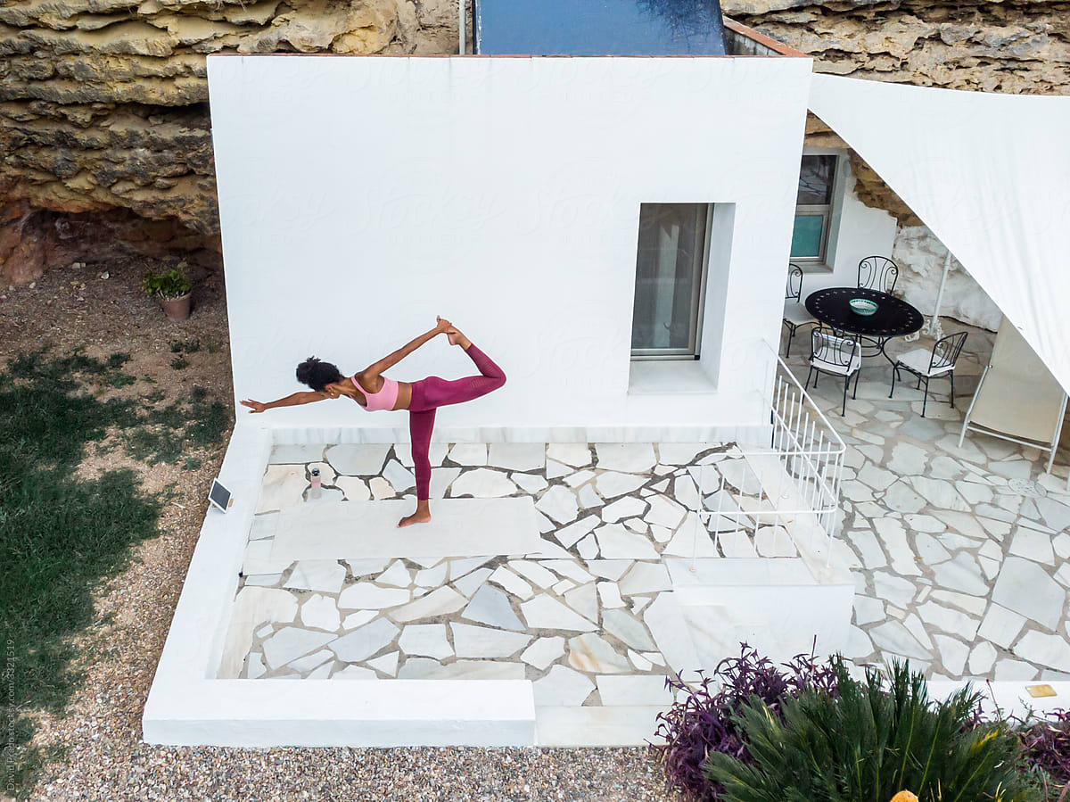 Black female doing yoga outside rock house