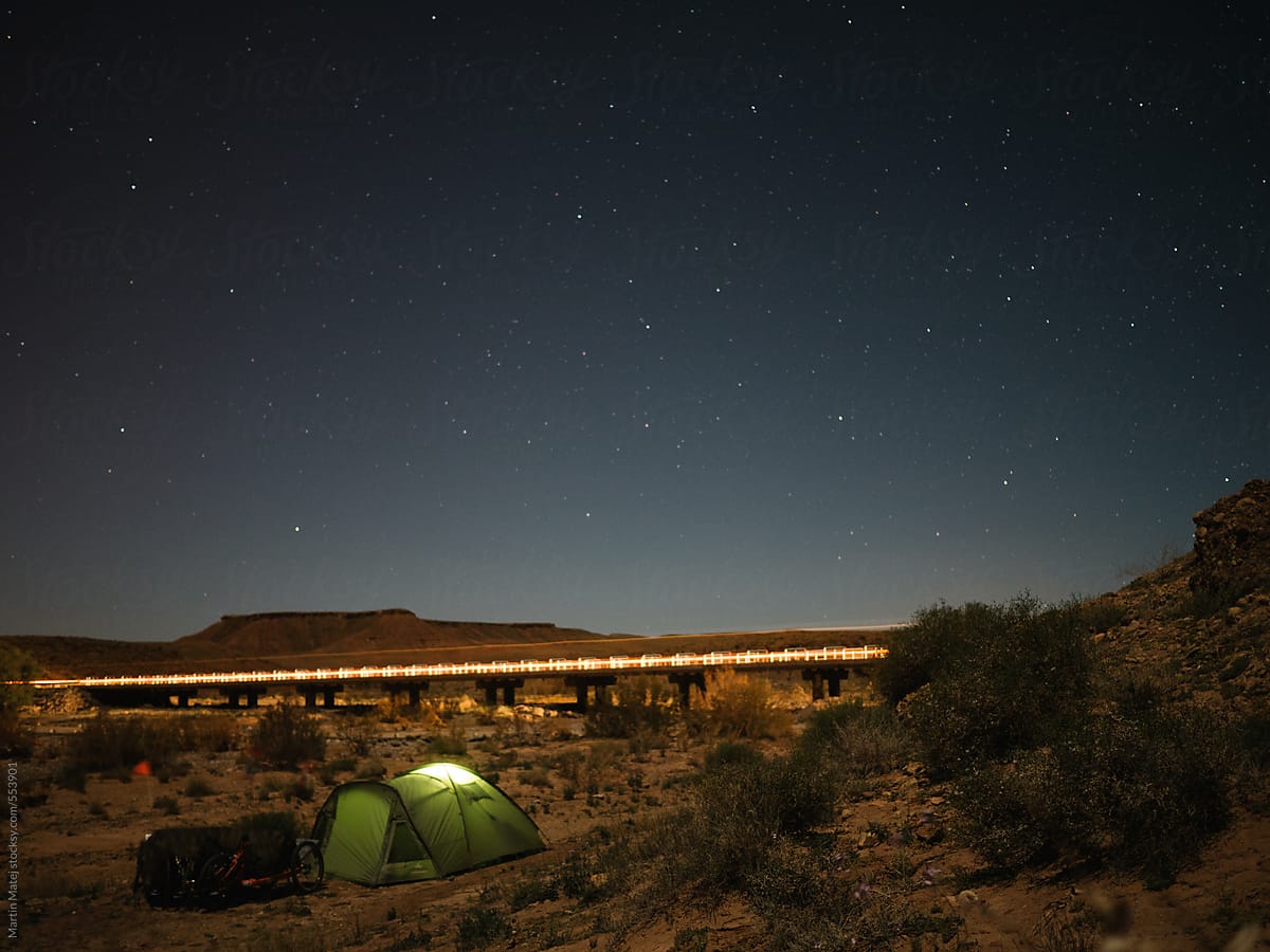 Camping in Moroccan desert near bridge enlightened by the passing car