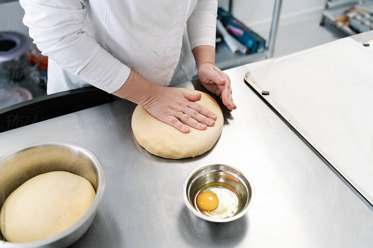 Baker kneading dough in commercial kitchen