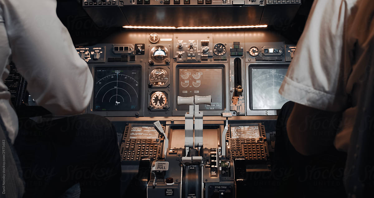 Pilots sitting at control panel in flight deck