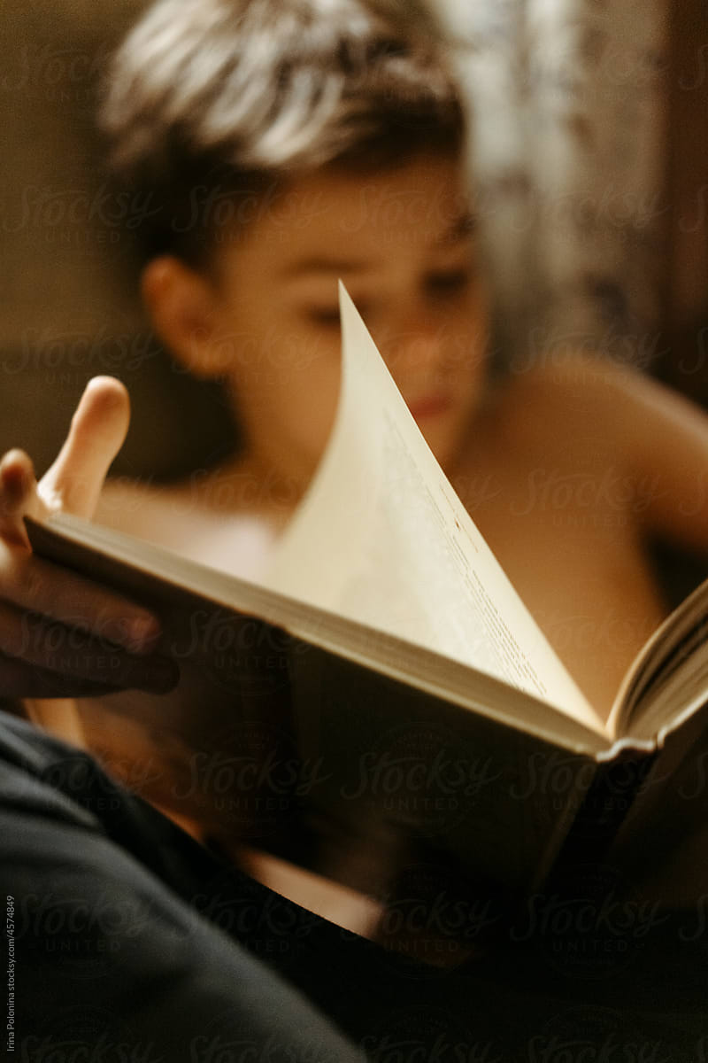 Young boy reads book.