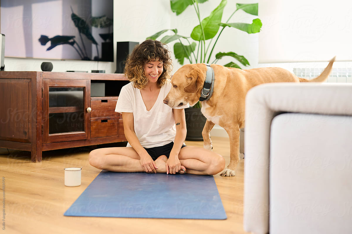 Happy woman with dog doing yoga