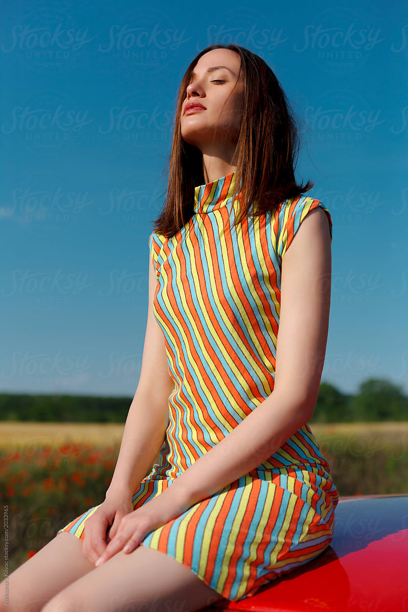 Woman Sit On A Car Hood And Enjoys The Sun By Stocksy Contributor Alexandra Bergam Stocksy 