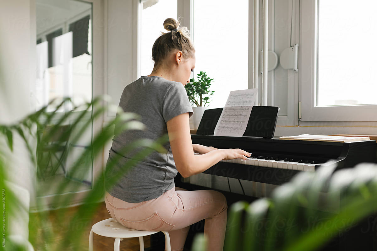 Woman Enjoying Playing The Piano At Her Home