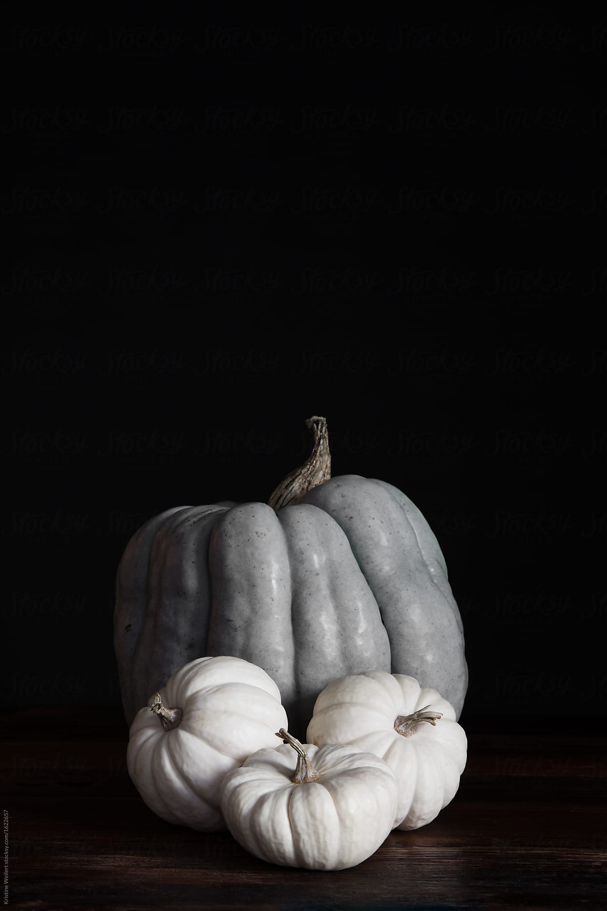Variety of pumpkins grouped on table with dark background