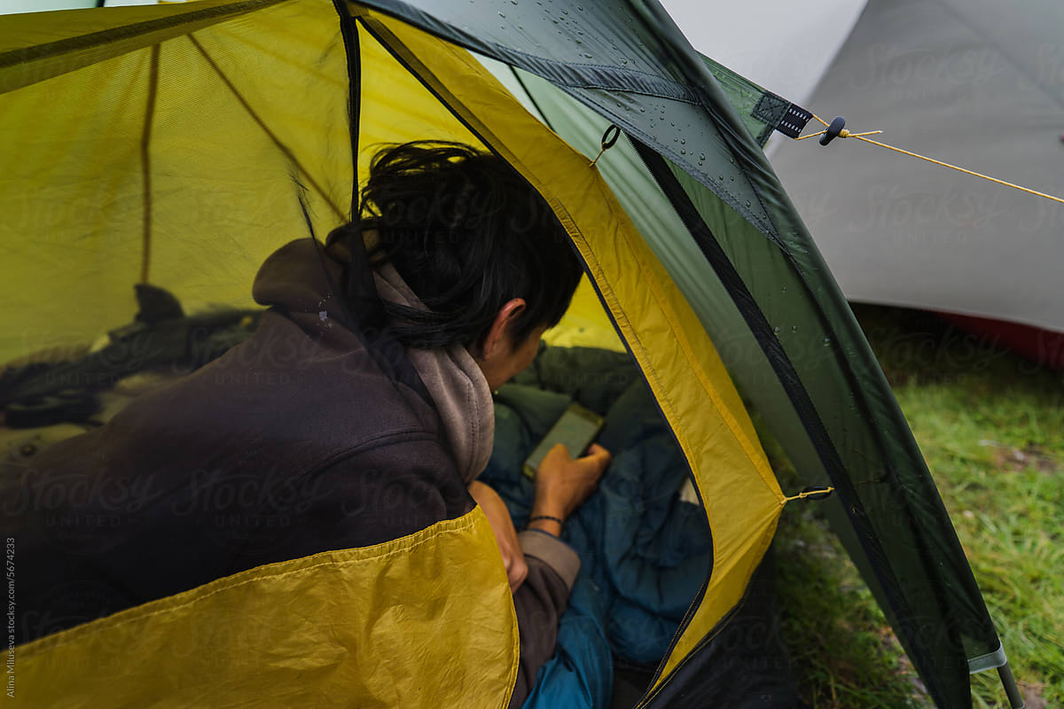 Man Using Phone In Camping Tent Outdoors