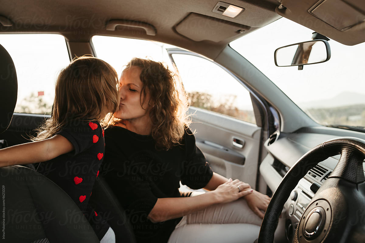 Happy woman traveling by car with little daughter.