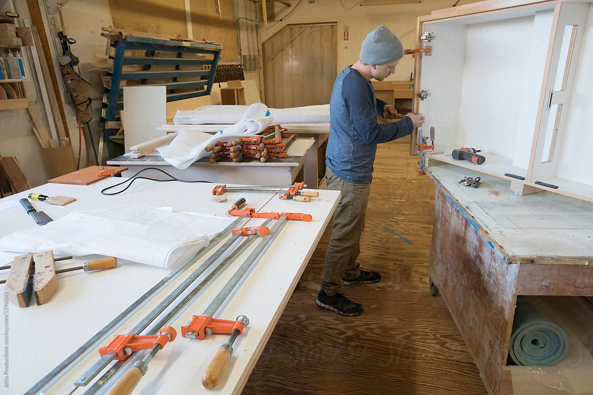 Craftsman assembles a cabinet in a small cabinet shop