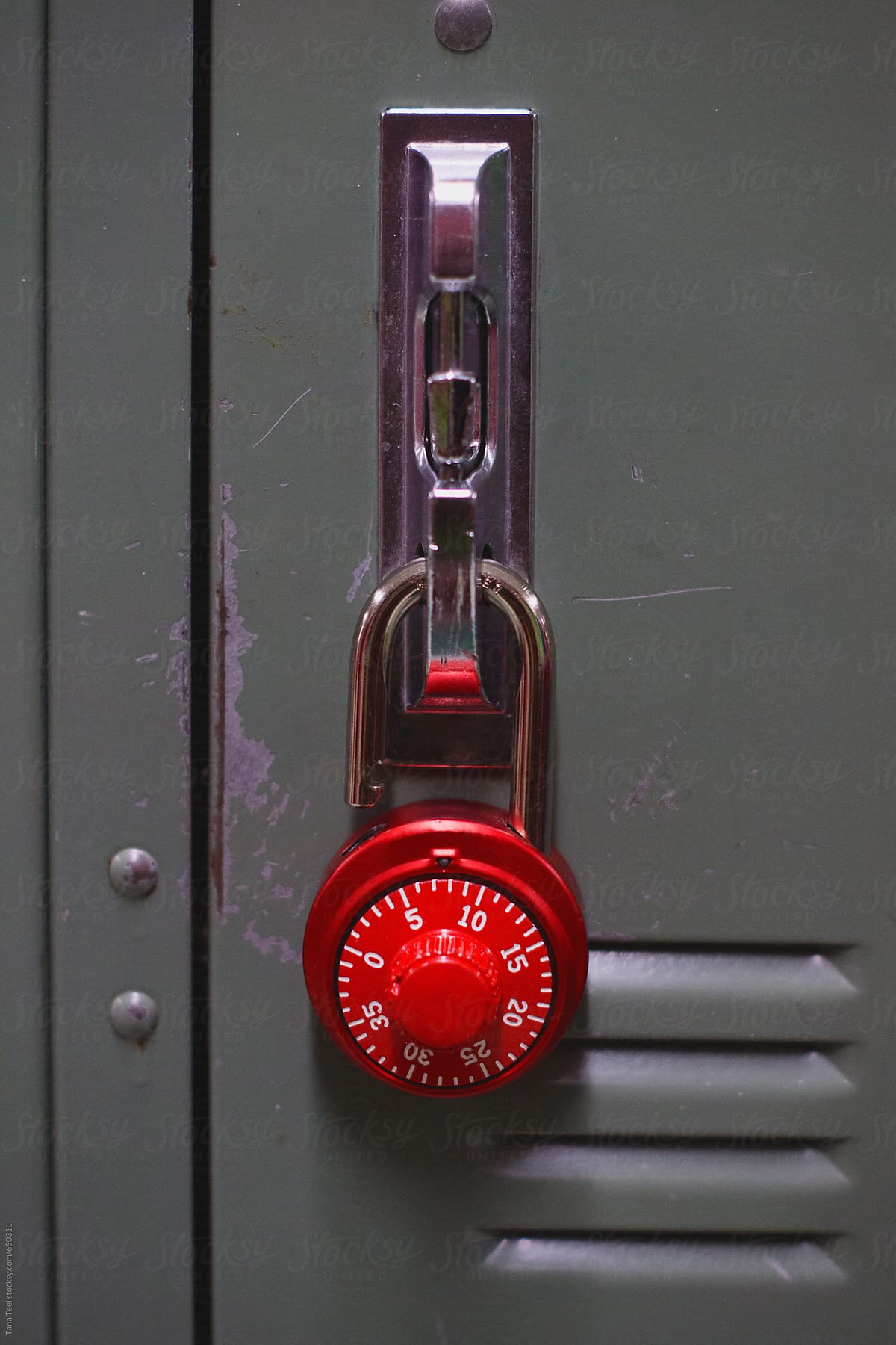 Red lock hangs on locker door handle