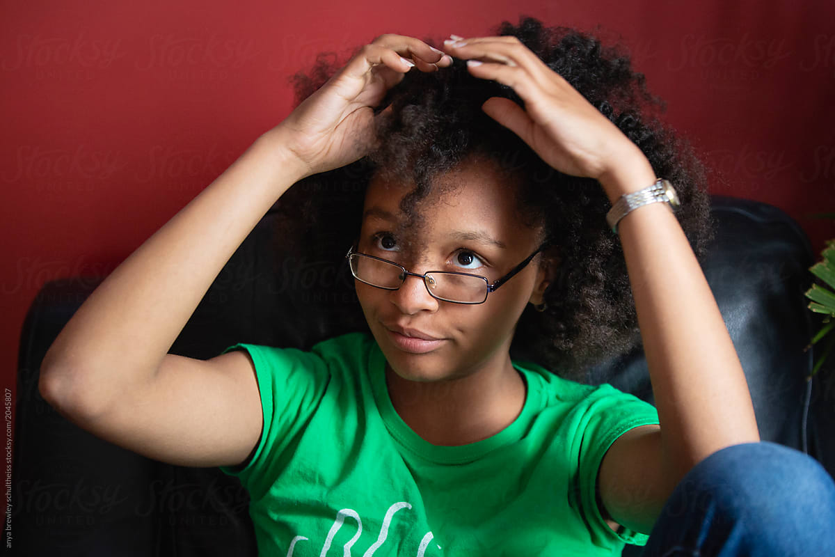 Teenager combing her kinky curly hair