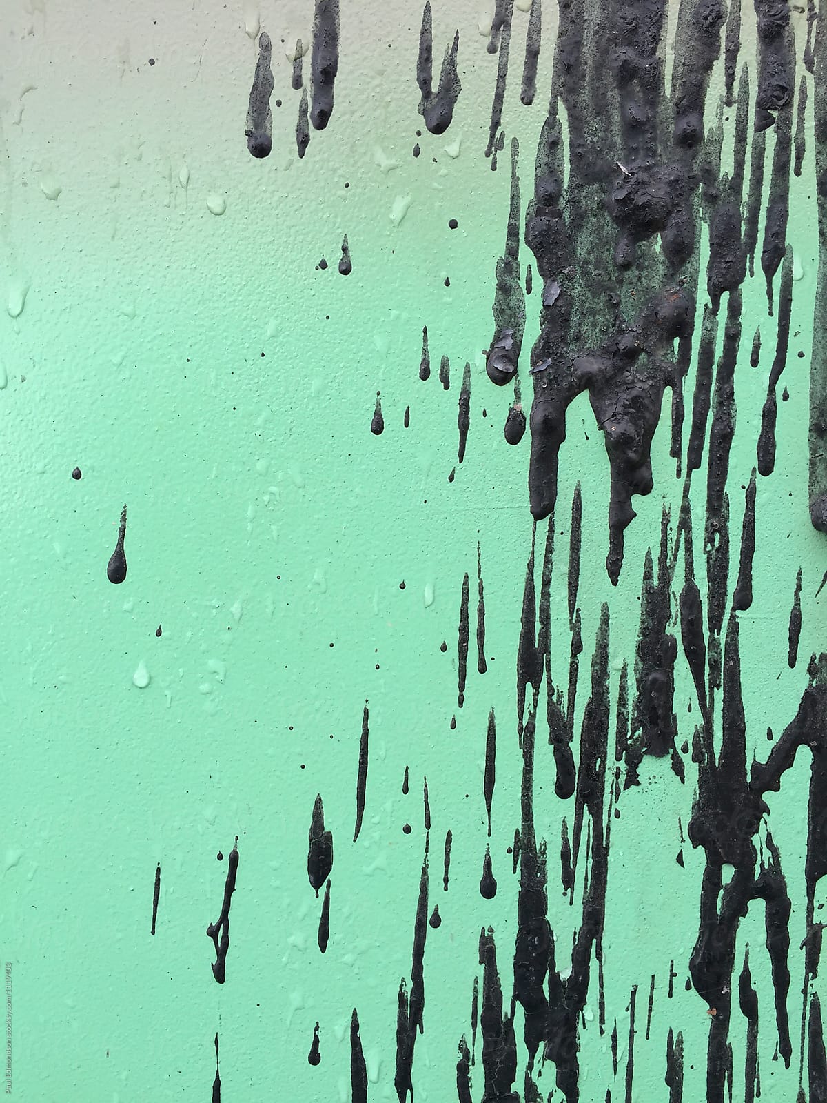 Close up of dripping black paint on metal trash container