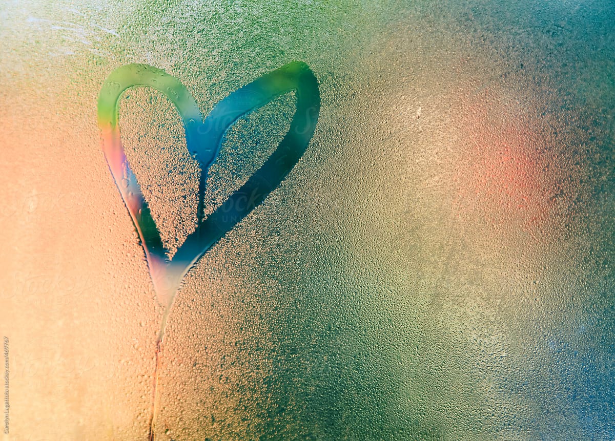 Heart drawn in heavy condensation on a window - peach background