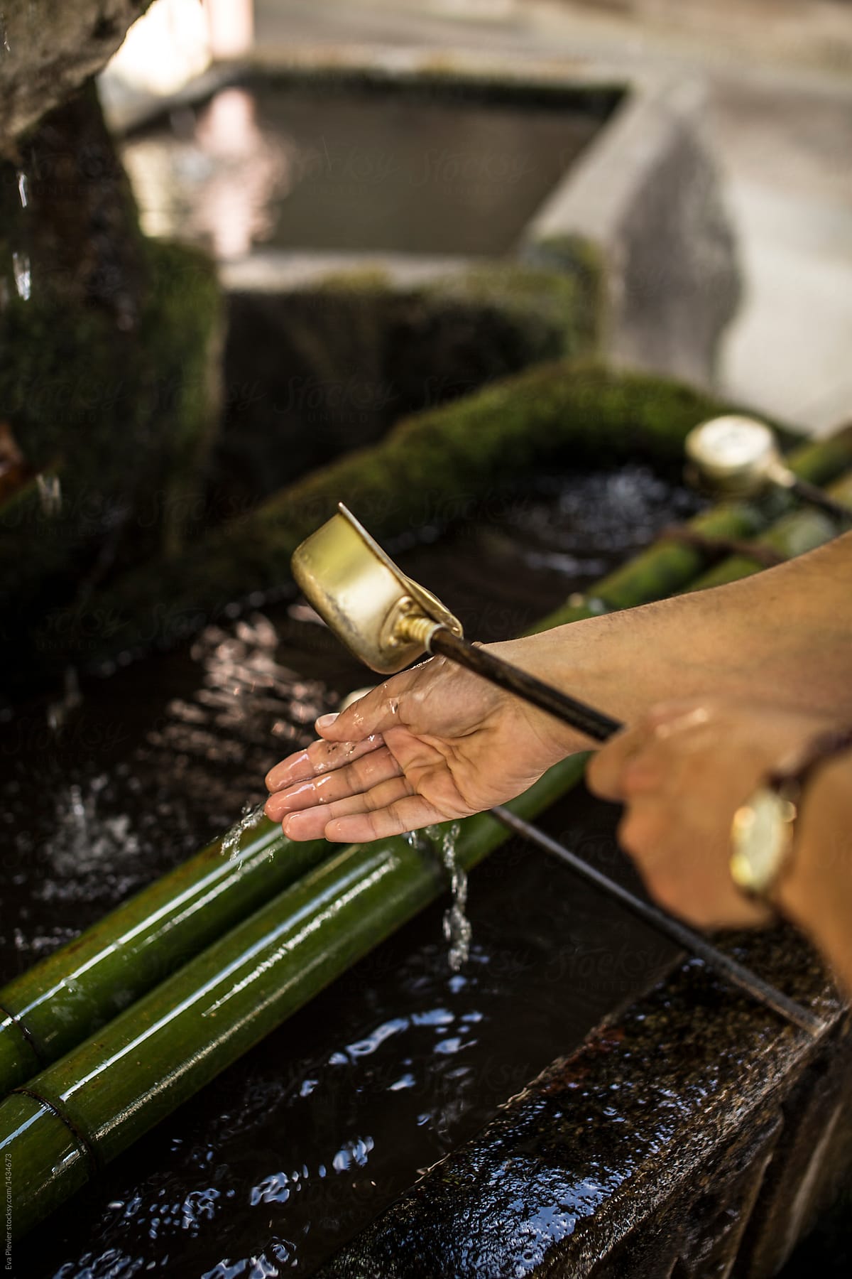 Man cleaning his hands before entering a temple.