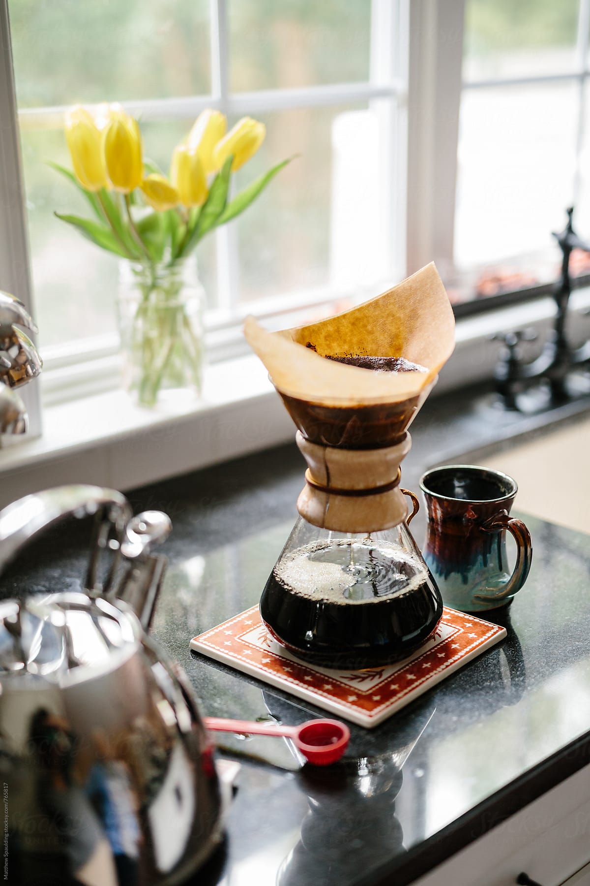 Fresh coffee dripping through filter on kitchen counter