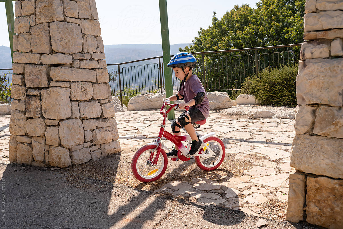 Kid in Helmet Learning to Ride a Bike. Young Boy Learns Biking