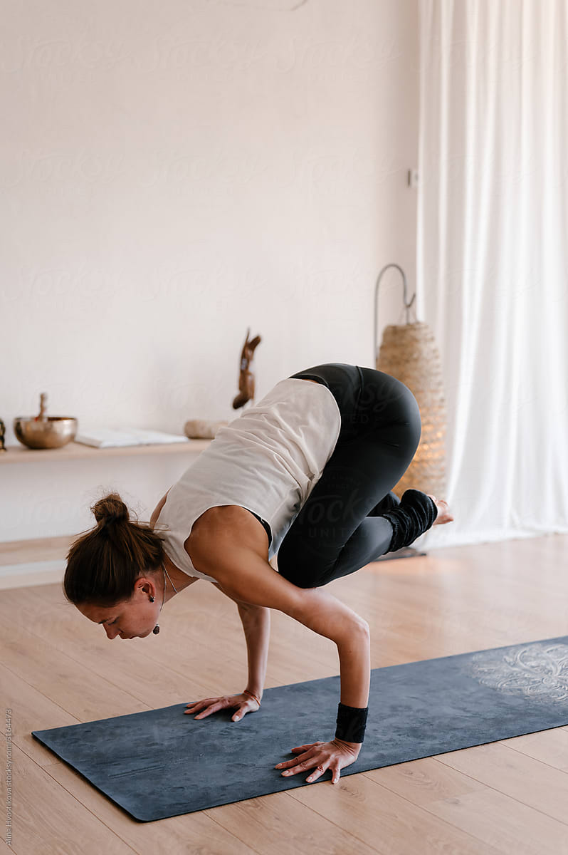 Young lady doing balance exercise in yoga studio