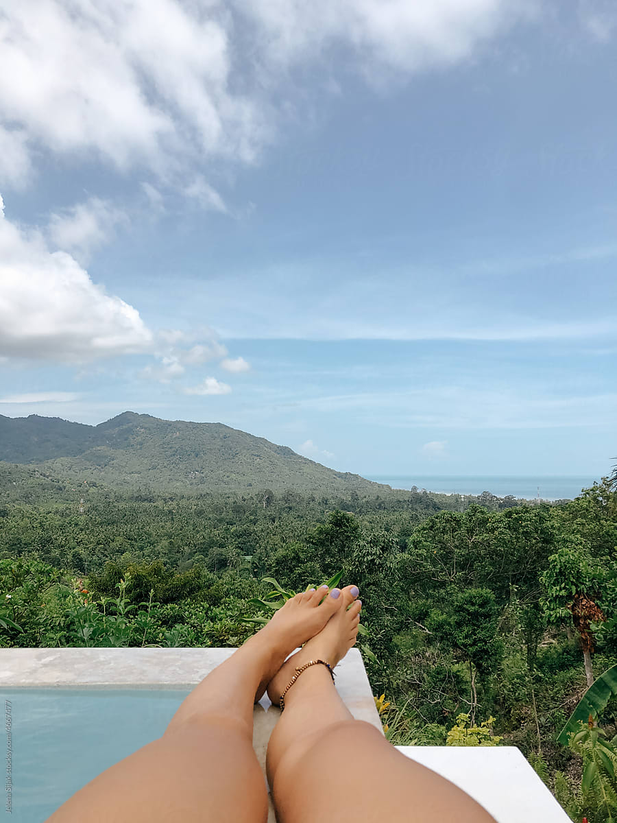 UGC, girl\'s feet, swiming pool, jungle and sea and sky horizon.