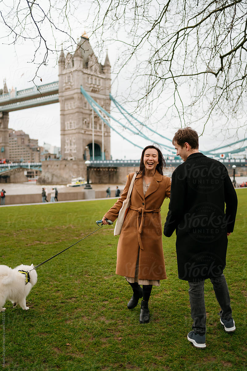 Happy couple with their dog in a garden in London