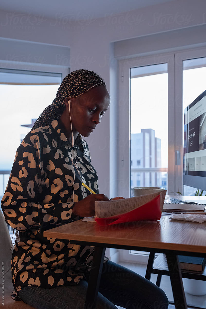 Black woman in earphones working remotely