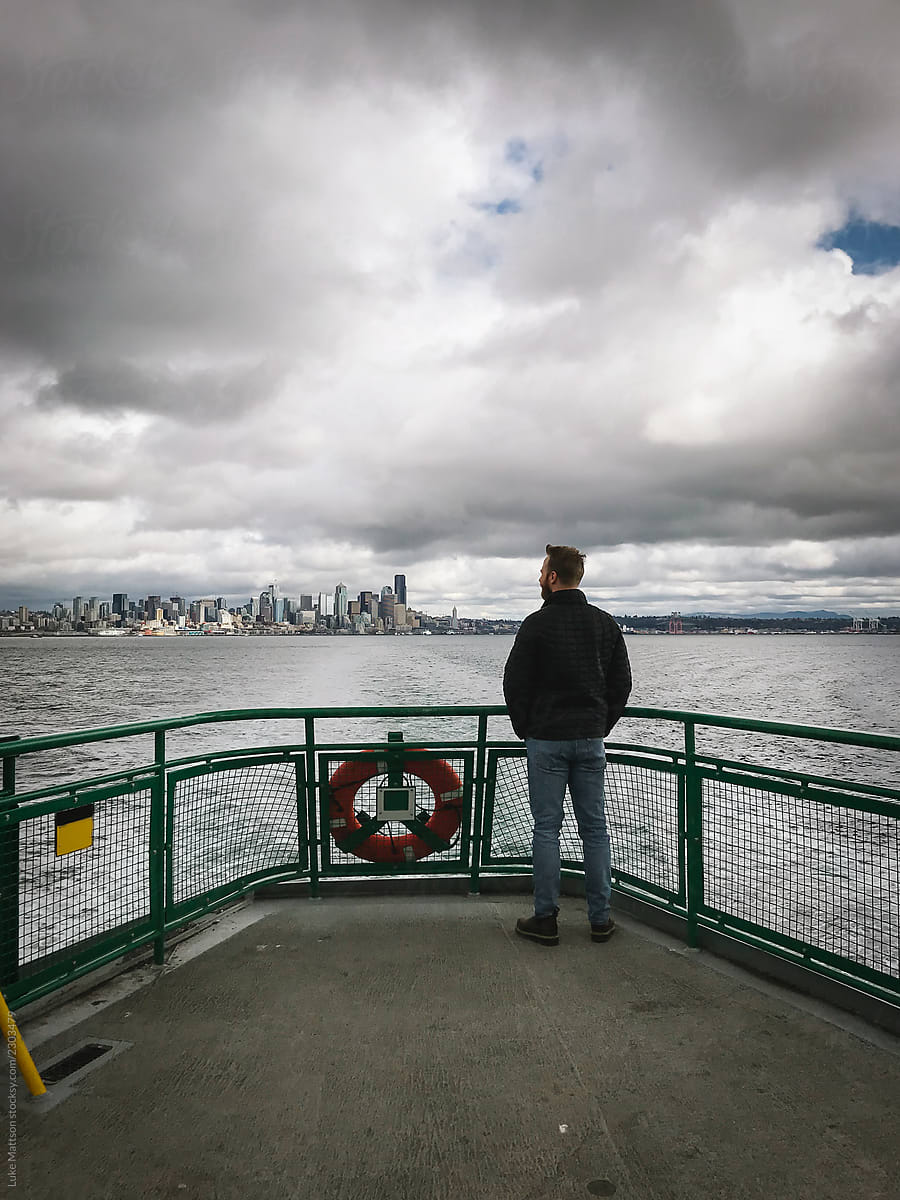 Man Viewing Seattle Skyline From Ferry Deck