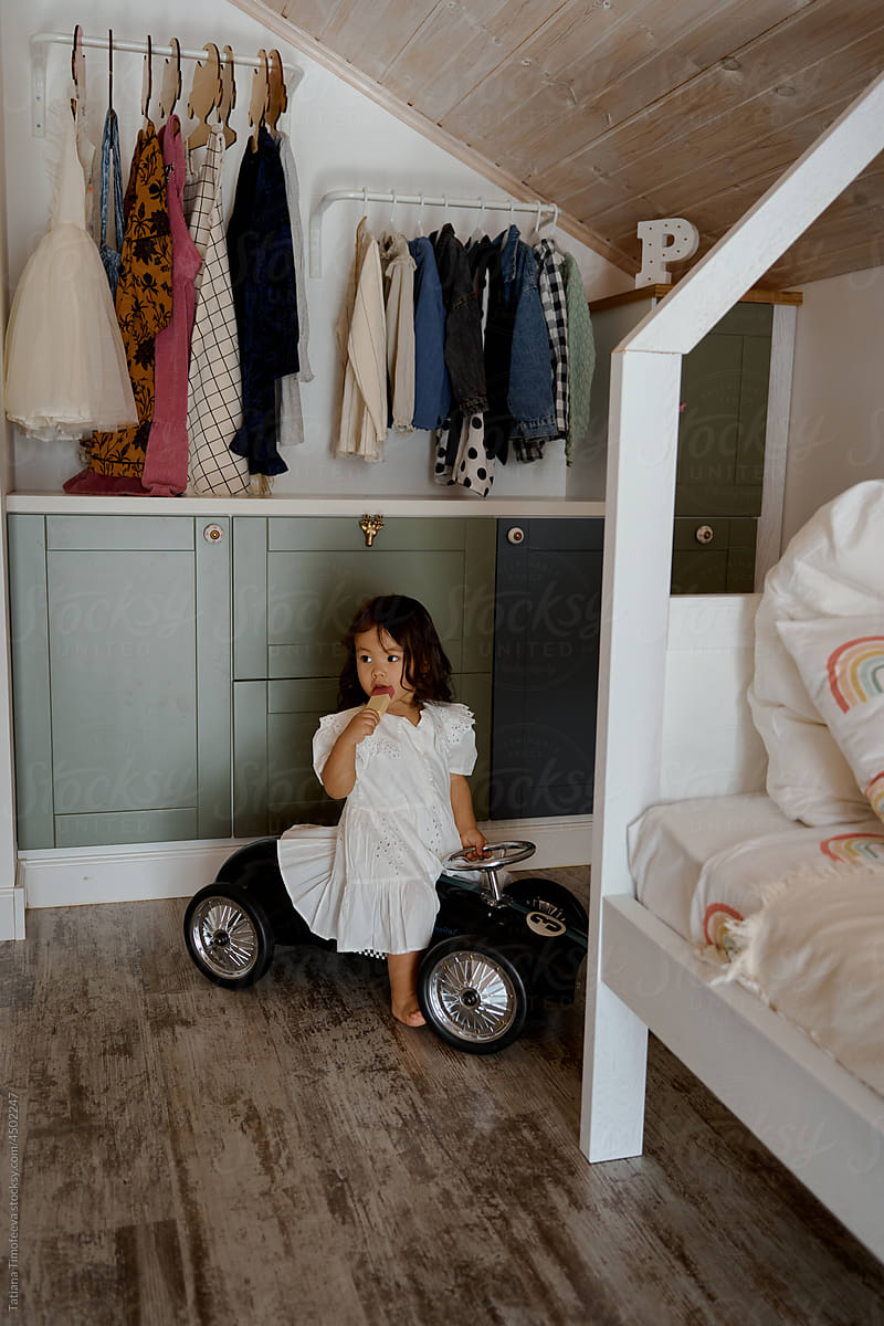 little asian girl playing with her toys and a small car