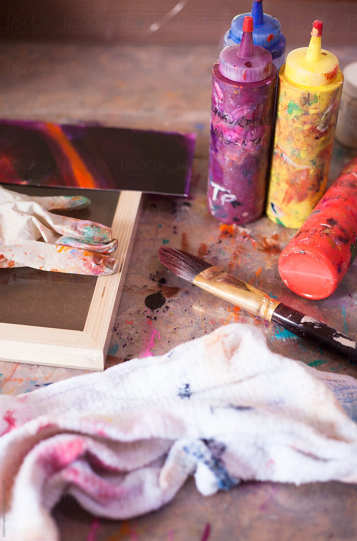 Paint brushes and bottles of paint in an artist\'s studio