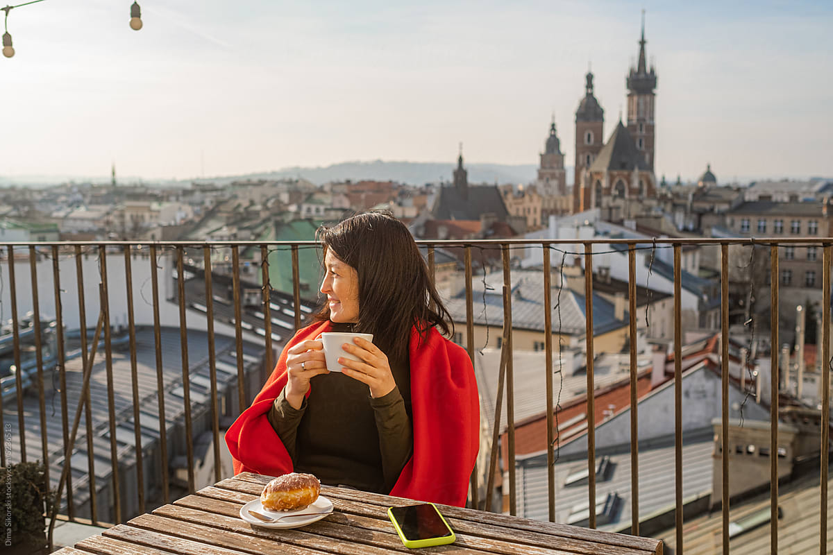A happy tourist has breakfast on the terrace in the old European city