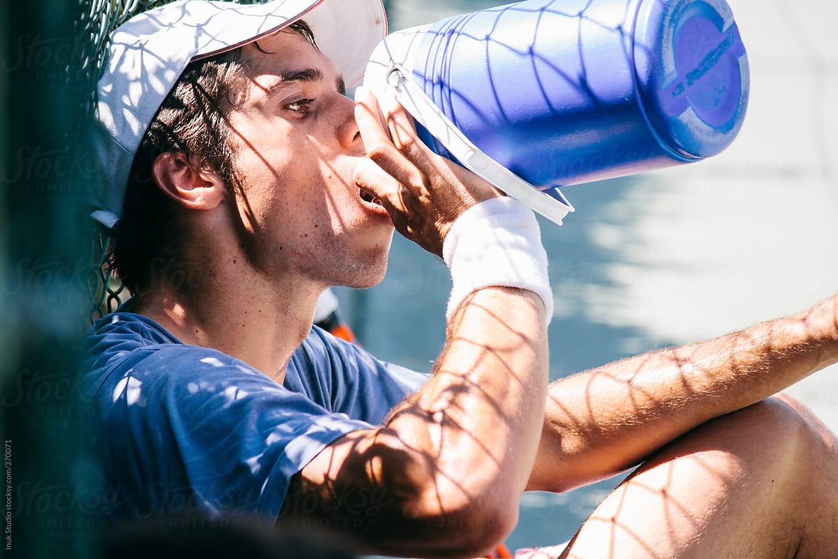 Tennis player drinking during a break from a tennis match