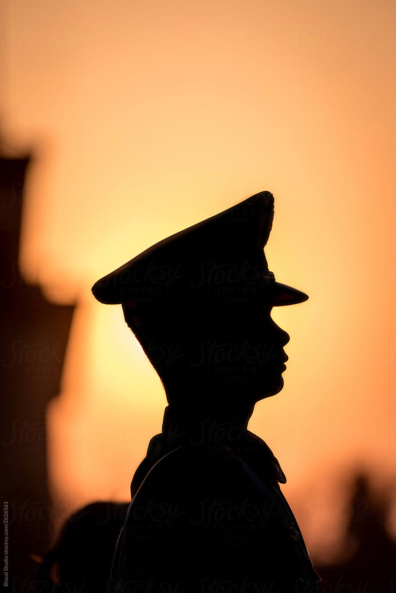 Military man in Tiananmen Square at sunset