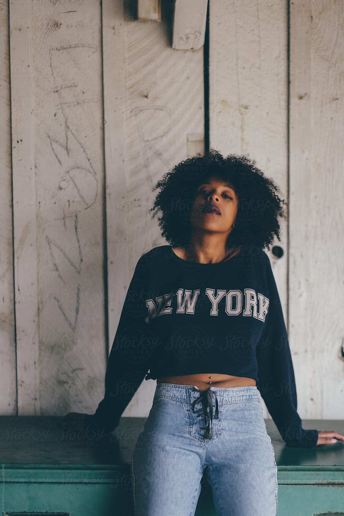 Curly haired woman in sweat shirt crop top