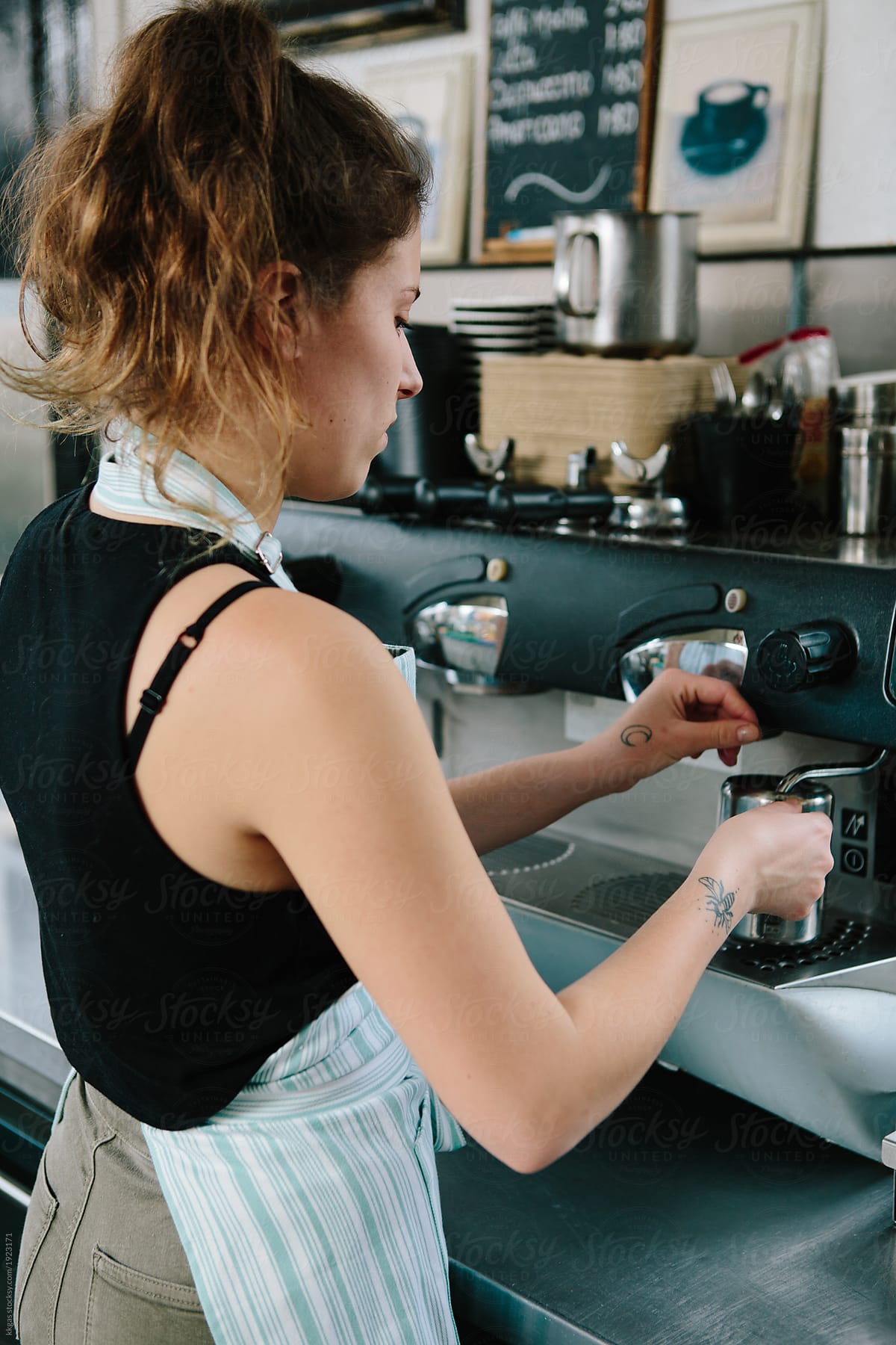 Young woman making coffee in a commercial kitchen