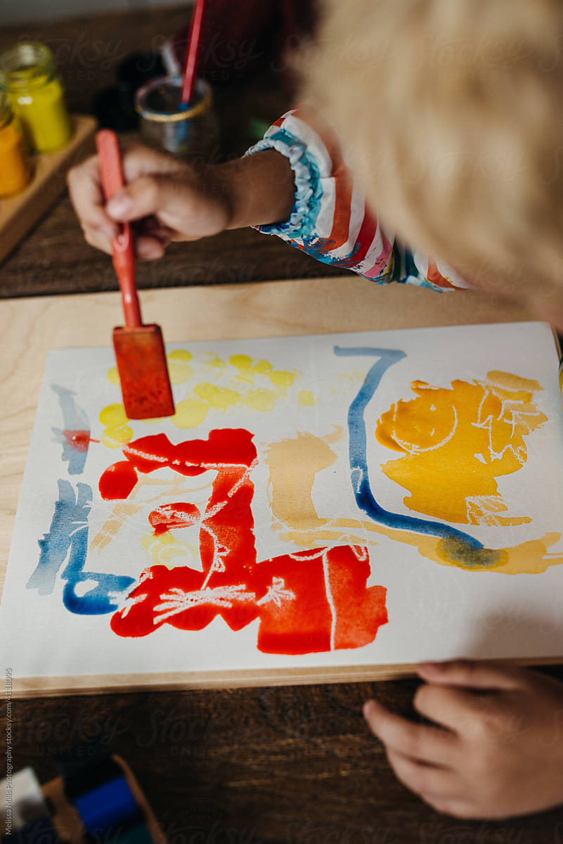 Young kid doing dab painting using various watercolours