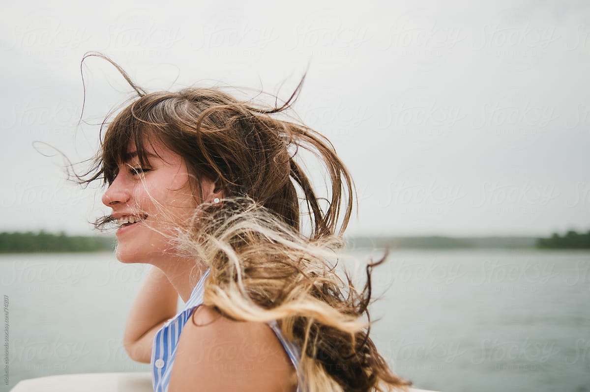 Teenage Girl On Lake With Wind Blowing Hair By Stocksy Contributor Michelle Edmonds Stocksy 5461