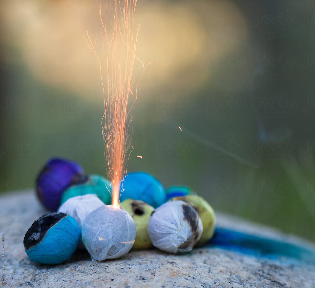 Bunch of colored smoke bombs with the flame shooting out of a white one