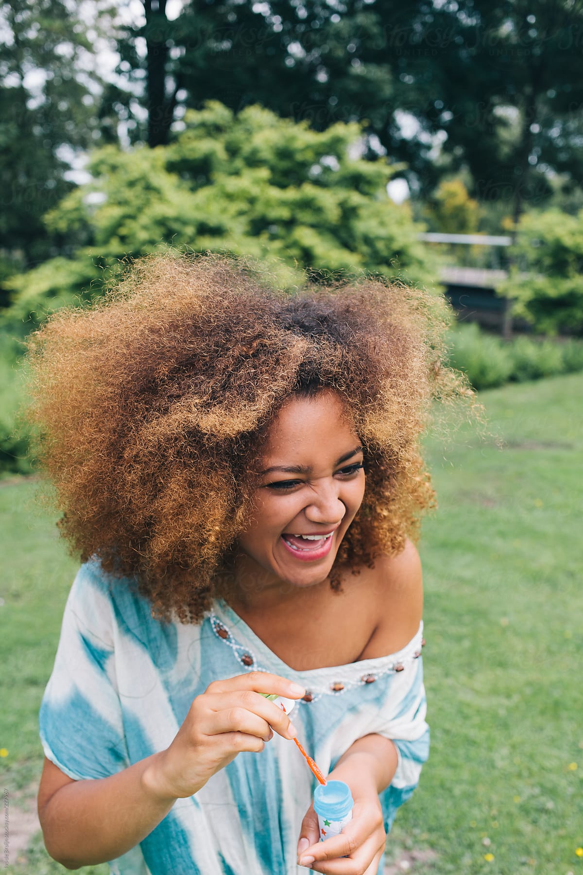 Girl With Big Afro Having Fun While Blowing Bubbles In The Park By Ivo
