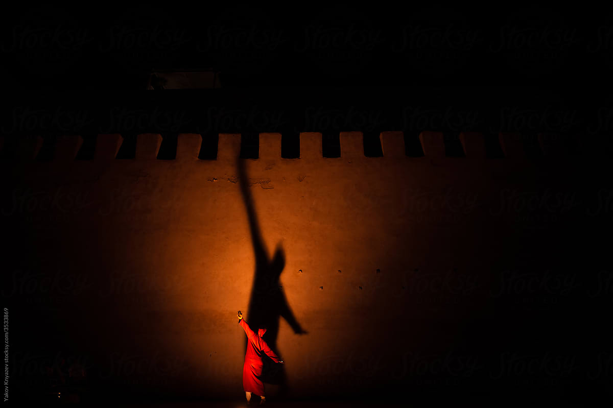 Woman dances against a backlit wall in Morocco