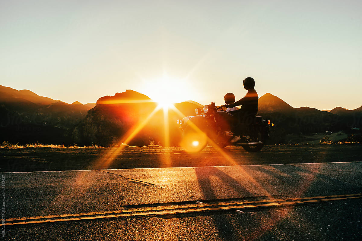 Young Anonymous Couple Watching Stunning Sunset on Motorbike Roadtrip
