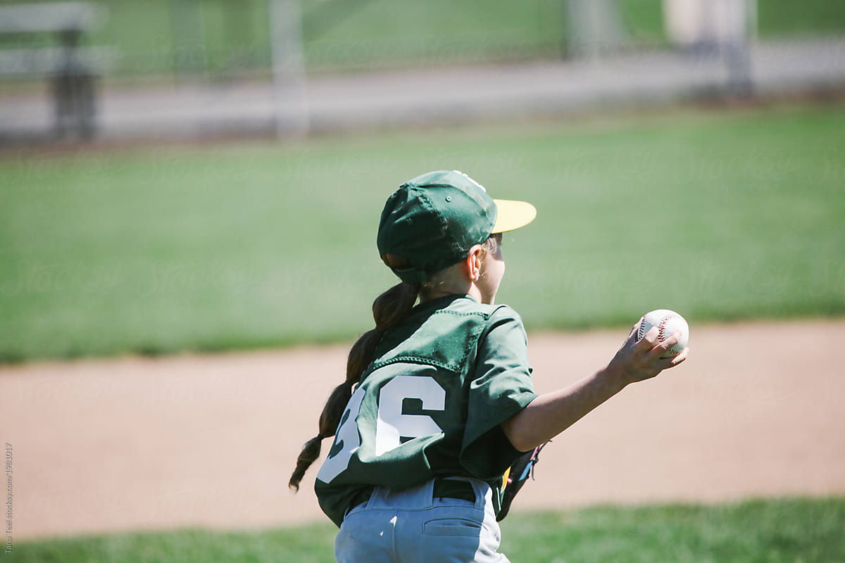 young girl throwing baseball