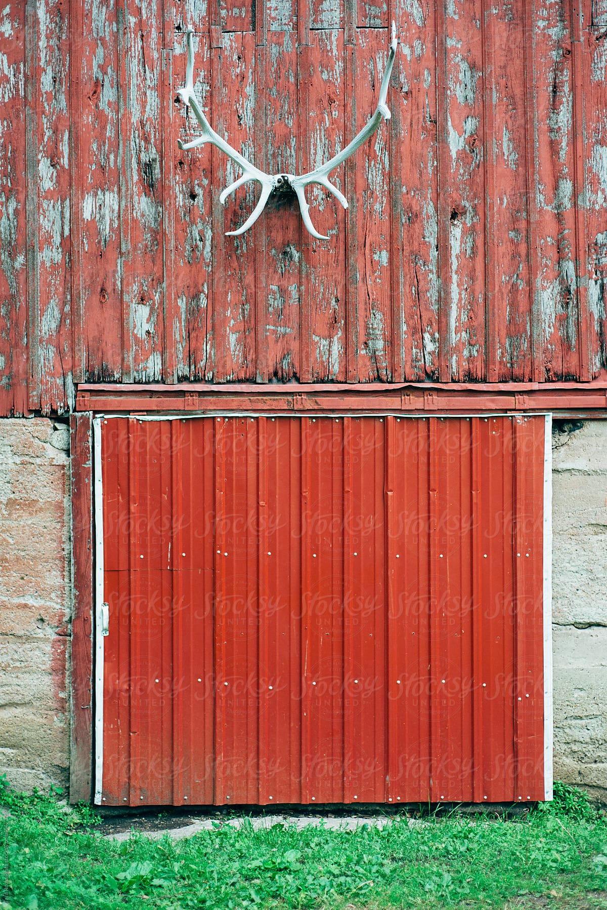 antlers hang above the door of a weathered barn