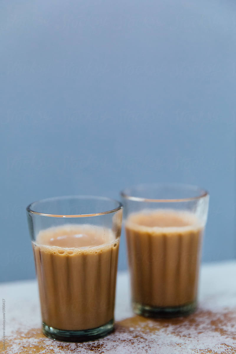 Two cups of Indian masala chai tea against a blue background