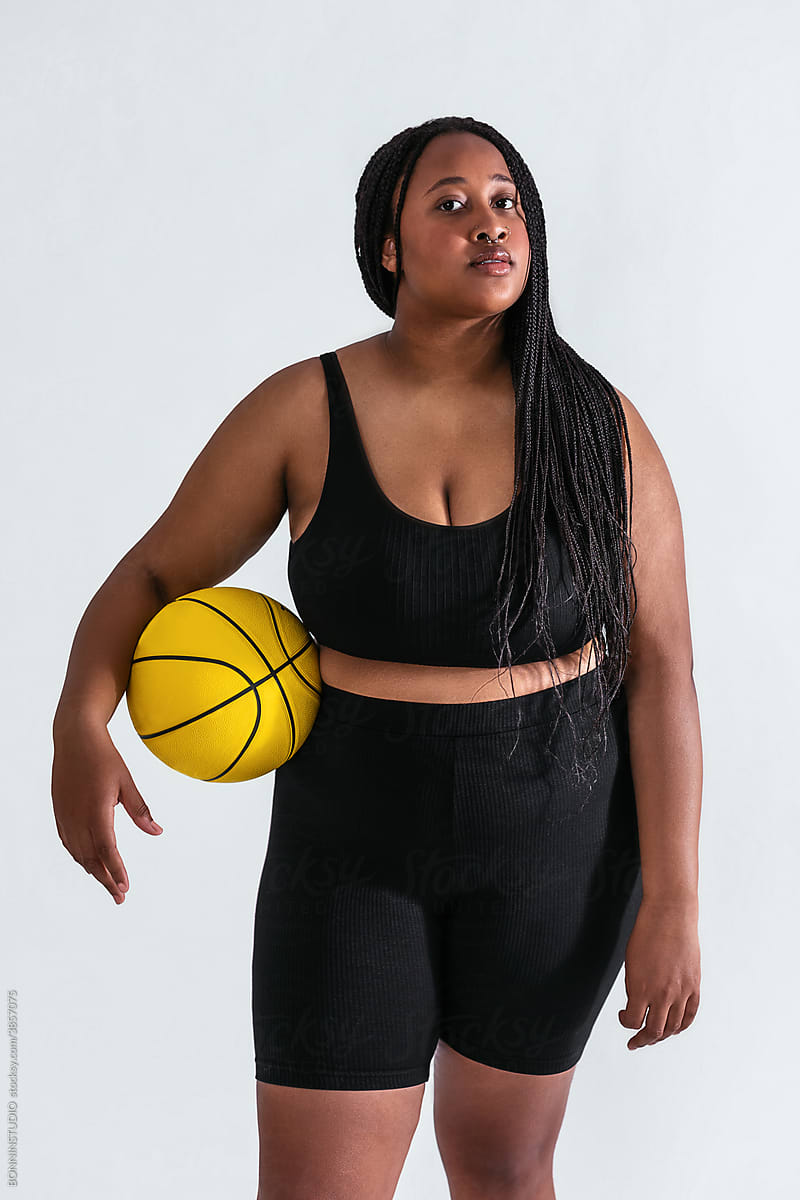 Curvy black sportswoman with basketball ball