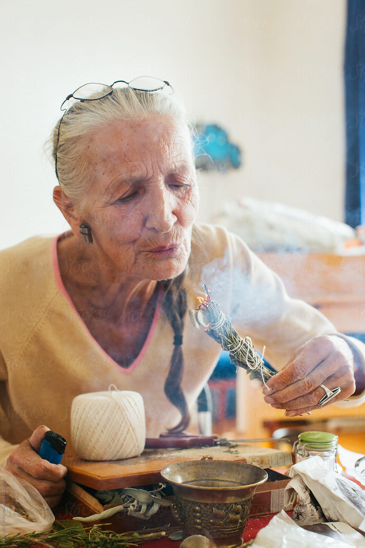 Environmental Portrait of Senior Woman with Grey Hair Lighting Smudge Stick