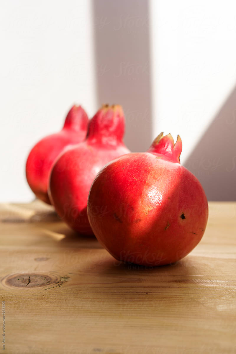 Ripe Pomegranates Fruits Rosh Hashanah Symbol on Wooden Table.
